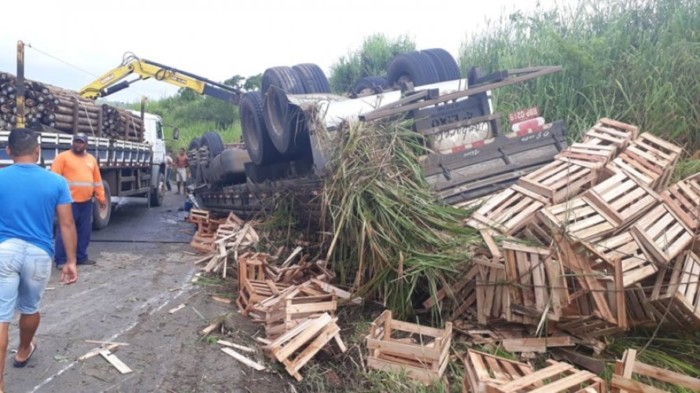Homem morre após caminhão com carga de caixotes tombar na Rodovia BR-101