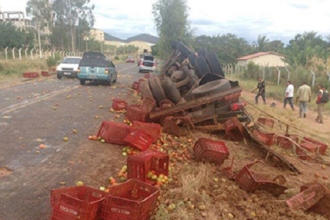 Caminhão carregado de tomate capota em rodovia esburacada, entre Tanhaçu e Ituaçu